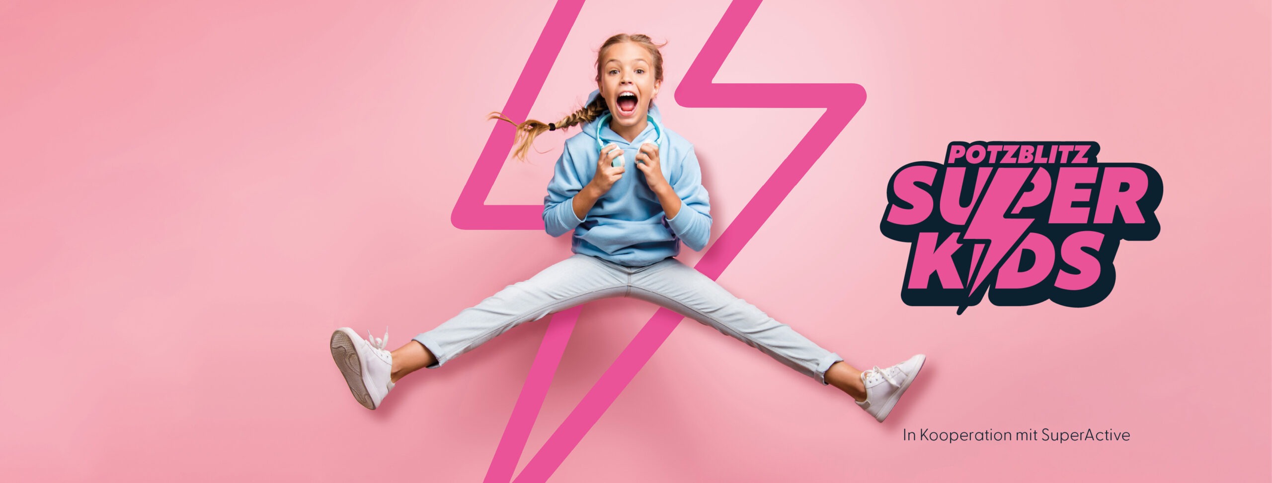 Superkids Banner - Mädchen springt hoch, im Hintergrund der SuperKids-Blitz in rosa