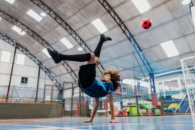SuperKids die im Turnsaal an der Sprossenwand hängen
